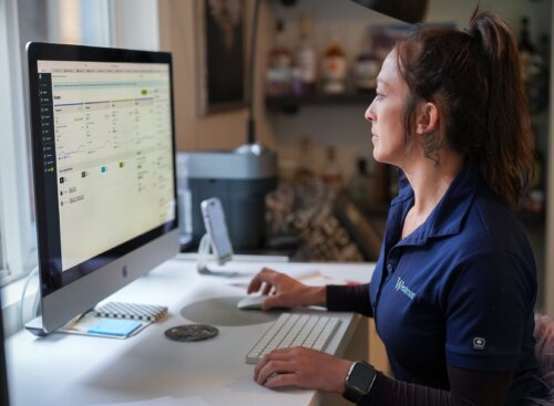 image of plumbing SP using Jobber on her computer to manage her daily operations.