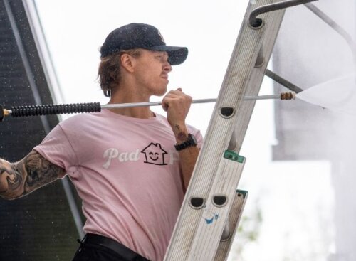 Pressure washing service provider cleaning the side of a home