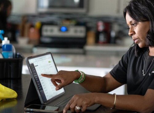 Cleaning service provider using Jobber on her tablet to manage her business operations