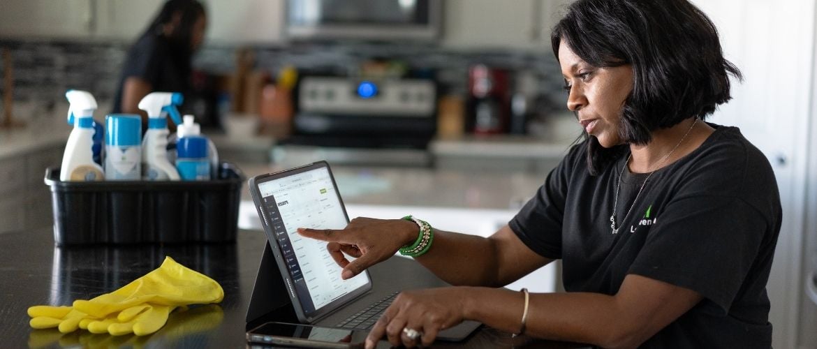 Cleaning service provider using Jobber on her tablet to manage her business operations