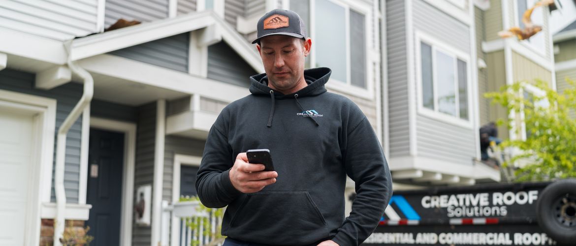 Roofing service provider using their smartphone to manage business operations