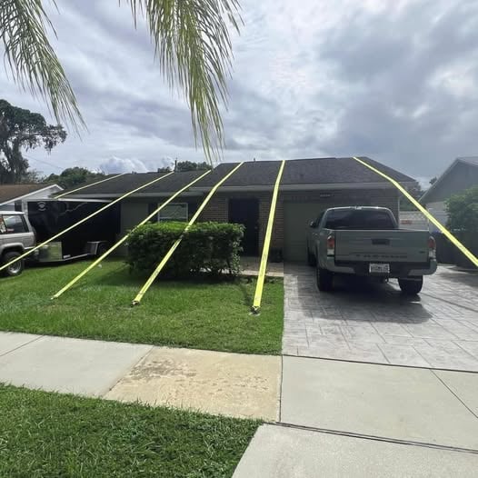 A house with bright yellow straps stretching from the roof to the ground with roofing meme caption