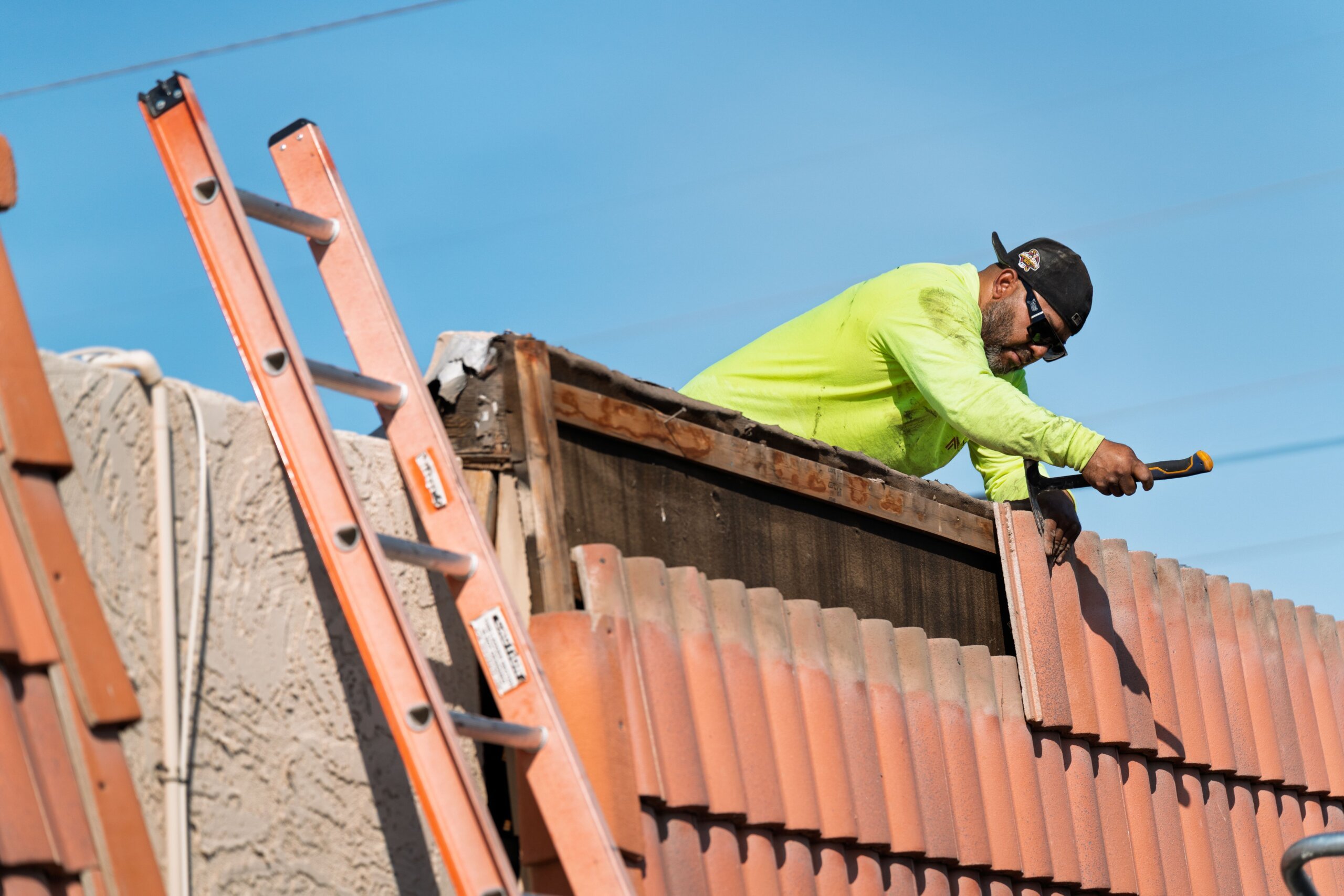 image of roofer installing tiles on roof