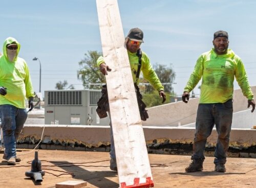 Construction workers on a job site. Feature image for how to build a construction estimate article.