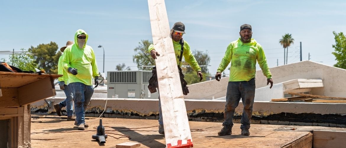 Construction workers on a job site. Feature image for how to build a construction estimate article.