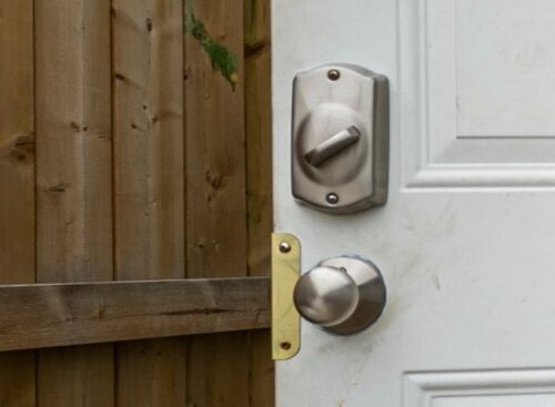Door with locks opening onto a wooden fence