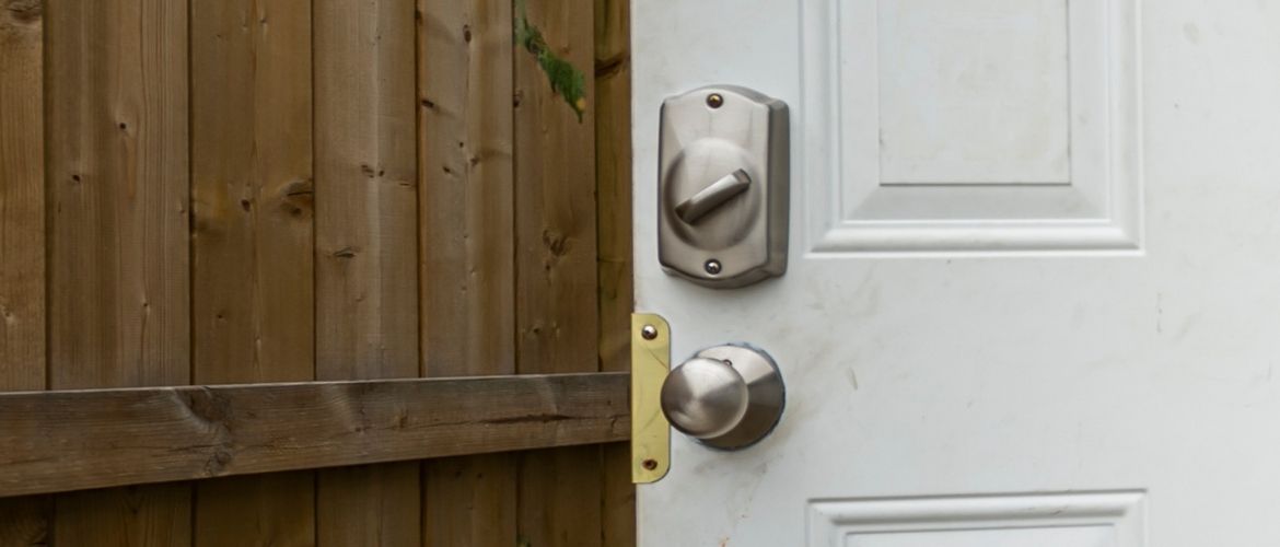 Door with locks opening onto a wooden fence
