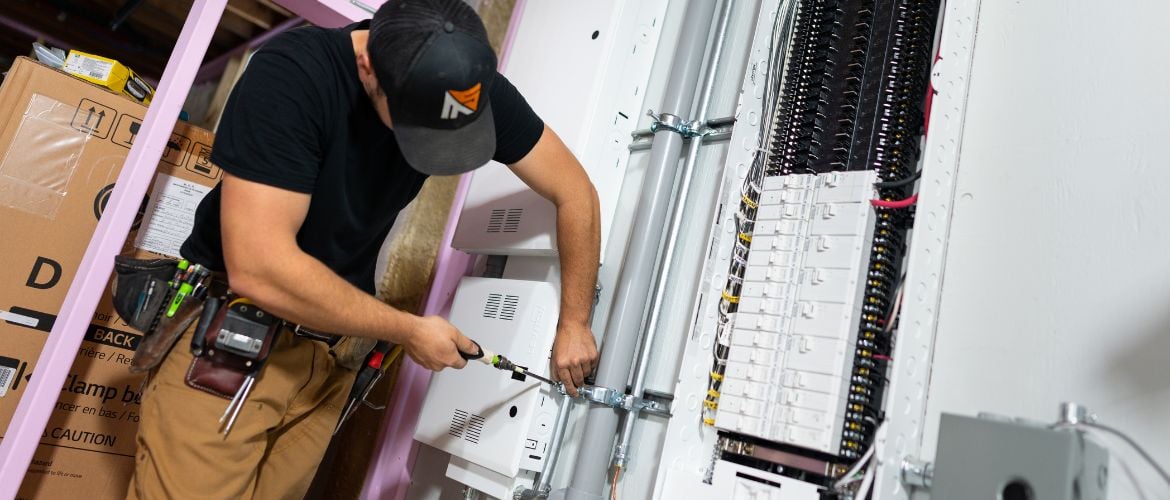 Electrician working on wiring inside a breaker panel