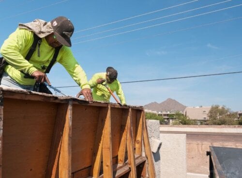 Two construction service providers installing or repairing a roof.