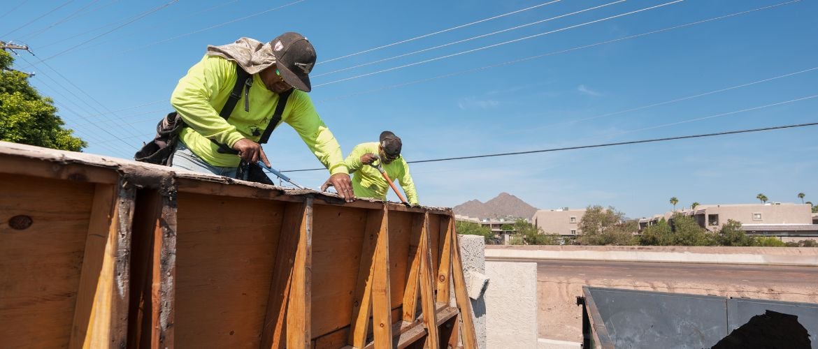 Two construction service providers installing or repairing a roof.