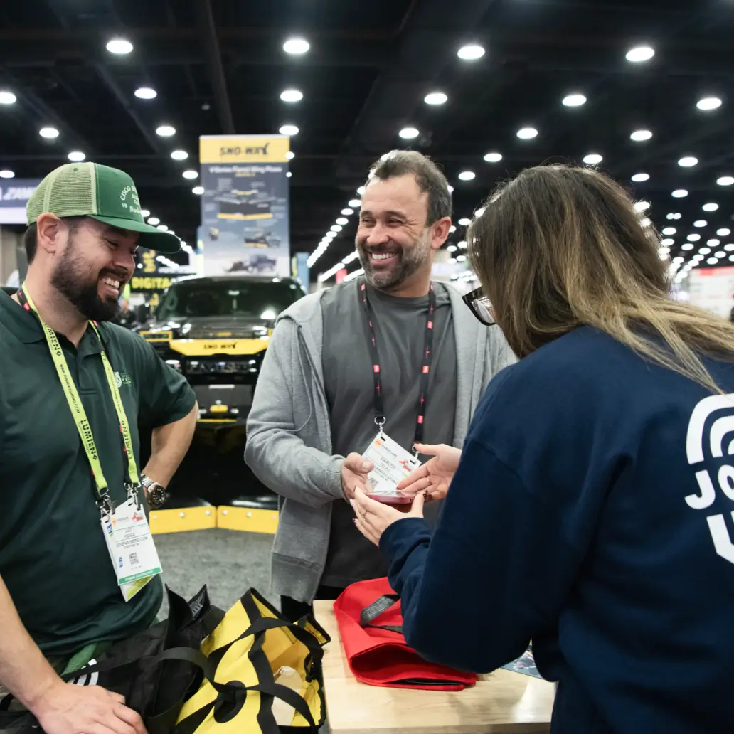 Two men and a woman standing at a trade show