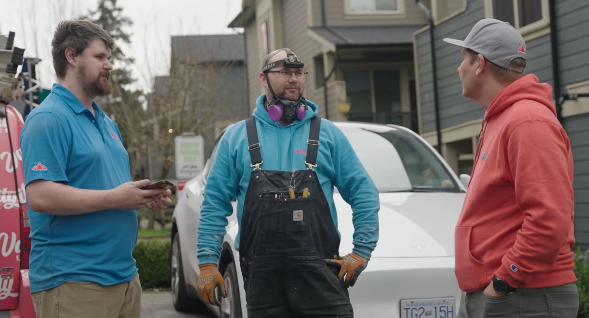 Electrical team meeting on a residential job site with technicians coordinating work and discussing tasks before starting service