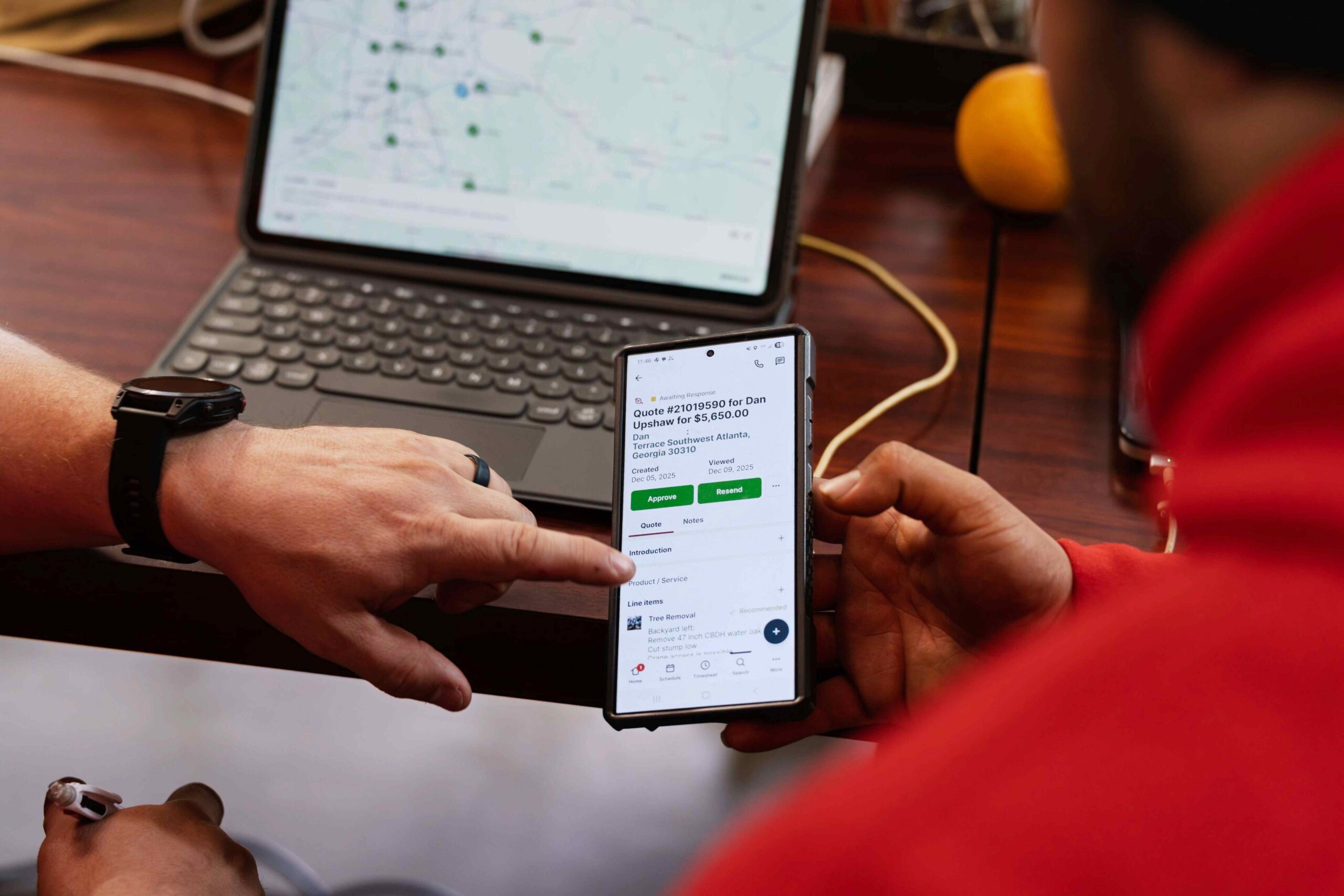 Team reviewing and approving a customer quote on a smartphone during a job