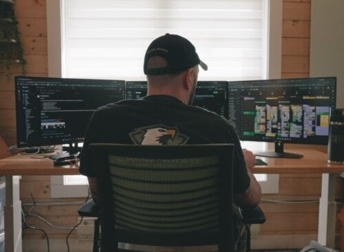 Camo Crew Responsible Junk Removal owner managing operations from a workspace displaying scheduling and Jobber software.