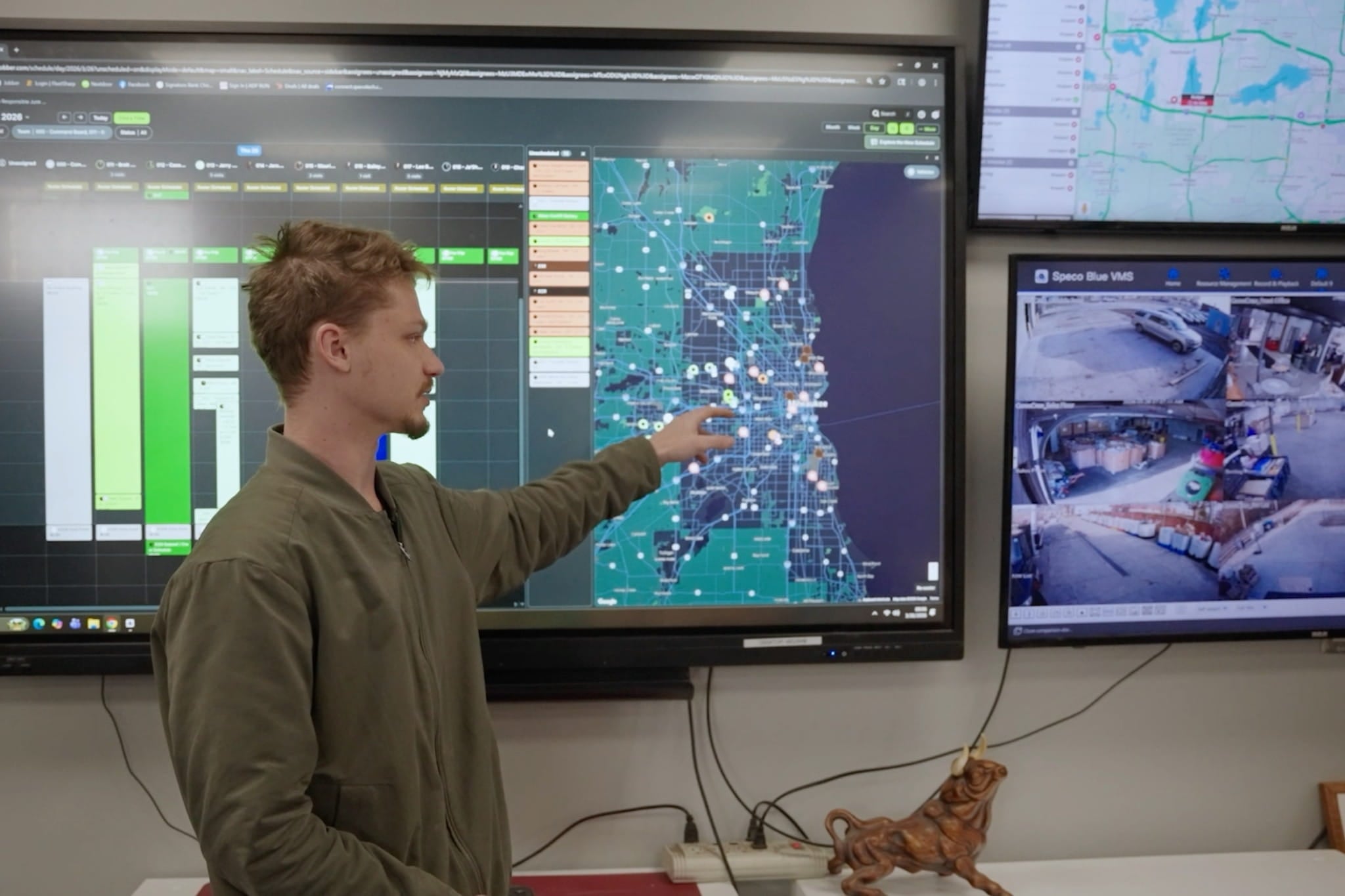 Camo Crew Responsible Junk Removal team member reviewing schedules, routes, and active jobs on a large dispatch screen.