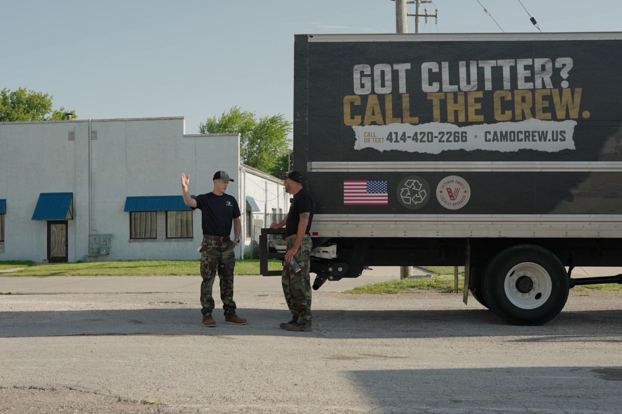 Camo Crew Responsible Junk Removal owner and team member standing beside a branded junk removal truck.