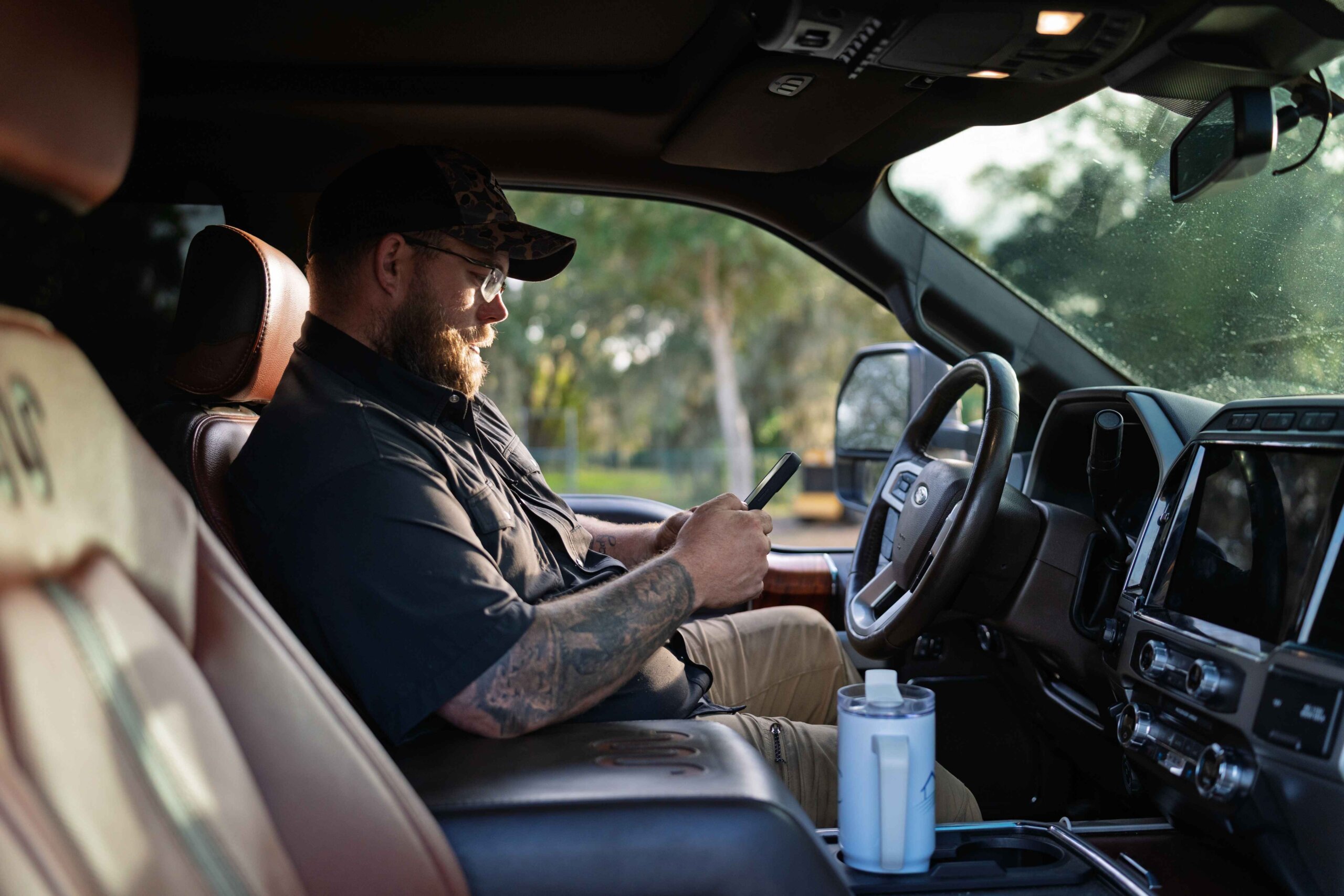 Chris Chase of Grass checking job information on a smartphone inside a work truck
