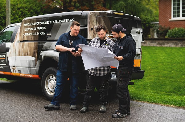 Three people standing by a van