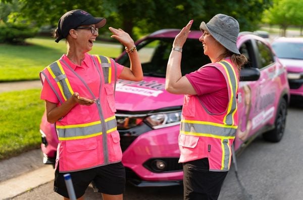 Kroopin's Poopin Scoopin owner Erica Krupin high-fiving crew member at a residential job site